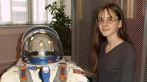 Claire Parfitt A 14-year-old girl stands beside Helen Sharman's space suit. The teenager is wearing a grey woollen jumper. The space suit is white.