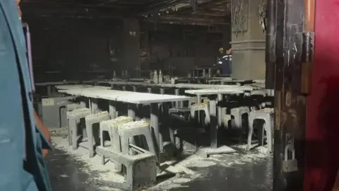 APTN Tables and chairs are covered in ash inside the venue, which shows huge fire damage. The picture is taken through a door frame.