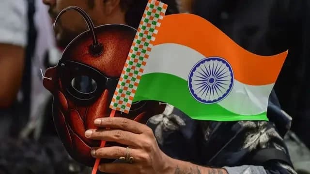 A supporter of CJP holds a cockroach mask and the Indian national flag during a protest