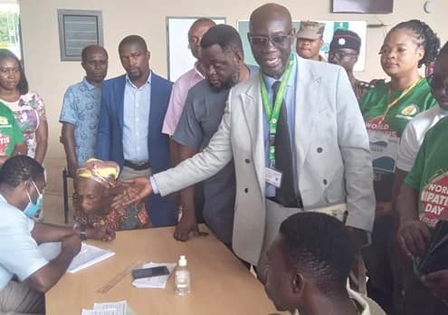Dr Fred Adomako-Boateng (hand stretched), Ashanti Regional Director of Health Services together with Charles Kofi Ogbeh (2nd from right) while interacting with some patients waiting to go through the screening exercise
