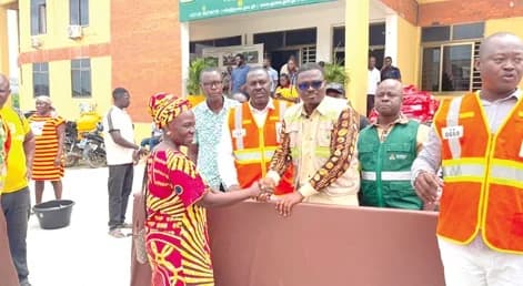 Emmanuel Adotey Allotey (3rd from right), Ga Central Municipal Chief Executive, presenting a student mattress to a flood victim.