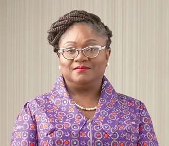 A formal portrait of Patience Akyianu, a prominent Ghanaian business executive who served as the Managing Director of Barclays Bank Ghana and CEO of Hollard Group. She is pictured wearing a purple patterned garment featuring the Hollard logo, glasses, and a pearl necklace.