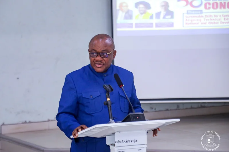 Benjamin Arthur, the Chief Executive of the Fair Wages and Salaries Commission (FWSC), is seen delivering a speech from a podium. He is wearing a blue suit and glasses, speaking at an event hosted by Accra Technical University as indicated by the background and watermark.