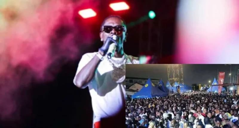 Ghanaian dancehall artist Shatta Wale is pictured performing live on stage under red lights and pink smoke. An inset photo displays a massive crowd of attendees at the outdoor festival venue in Ho, which features several blue promotional tents.